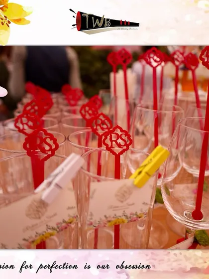 Custom "RS" monogrammed stirrers in vibrant red, perfectly matching the colorful theme of Srishti & Rohan's Mehendi celebration.