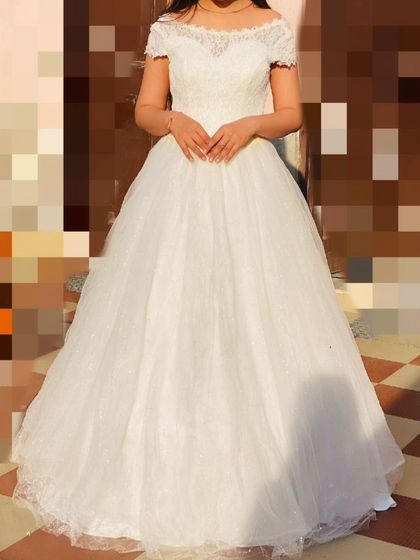 This version of the white ball gown features an off-shoulder lace neckline, adding a touch of romance. It's a beautiful option for a pre-wedding shoot.