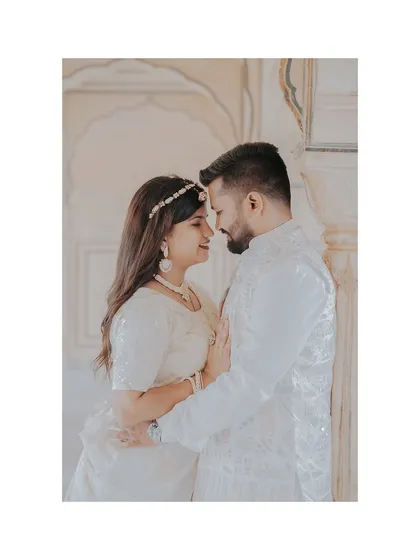 A romantic close-up of the couple in matching white traditional outfits, highlighting their emotional connection.