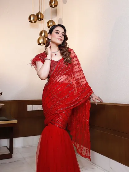 A full-length shot of the red draped saree with a mermaid-style bottom, combining traditional elegance with a modern silhouette.