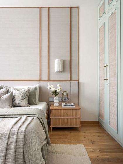 Designed for the grandparents, this bedroom embodies warmth and timeless charm. The bespoke bed features an elegant headboard framed in oak wood with a textured grasscloth wallpaper. A palette of soft greens, warm greiges, and honey-toned oak creates a pleasant and effortlessly inviting atmosphere.
