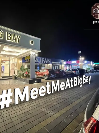 A duplicate of our inviting night shot with the #MeetMeAtBigBay sign, a perfect image to convey our vibrant evening atmosphere.