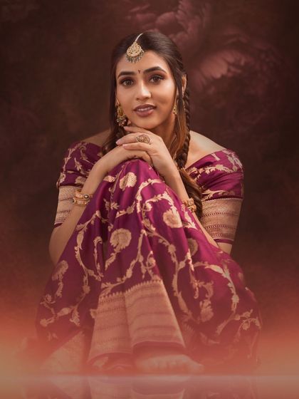 A warm, glowing portrait of Sapthami Gowda, her expressive eyes and beautiful saree creating a captivating image.