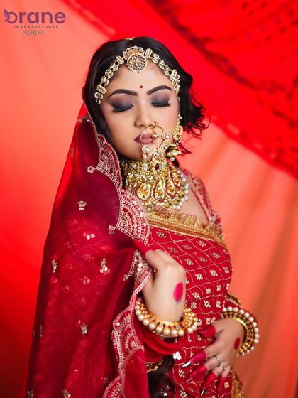 This side profile with closed eyes allows a detailed view of the eyeshadow blending and the traditional jewelry.