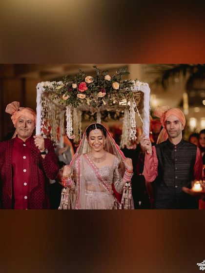 A focused shot of the bride's happy face as she walks under the phoolon ki chadar.