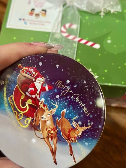 A close-up of one of our festive Christmas tin lids, featuring a classic Santa and reindeer design. We pay attention to every detail of the packaging to enhance the gifting experience.