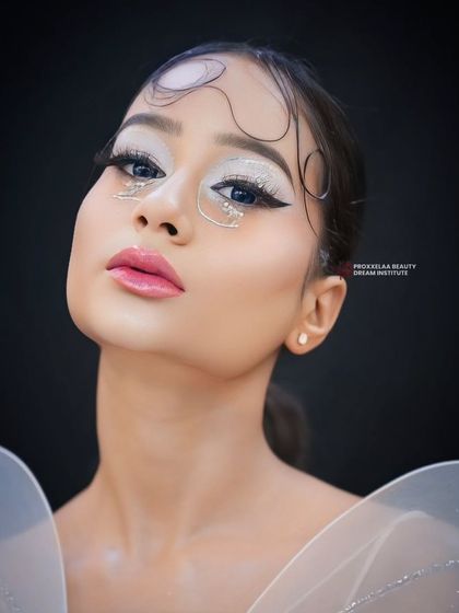 A close-up portrait of the fairy look, showcasing the icy-white eyeshadow and intricate rhinestone patterns that give it a magical, pixie-like quality.