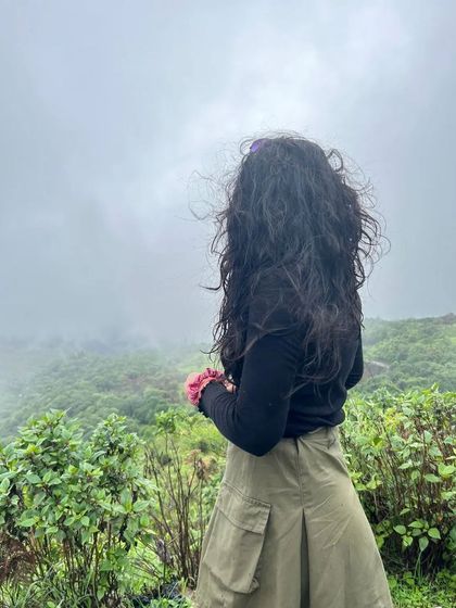 A trekker looking out at the beautiful, fog-covered landscape of the Western Ghats.