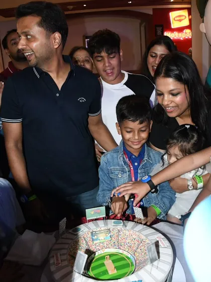 The excitement is palpable as the family celebrates Prishiv's 8th birthday with his custom cricket stadium cake.
