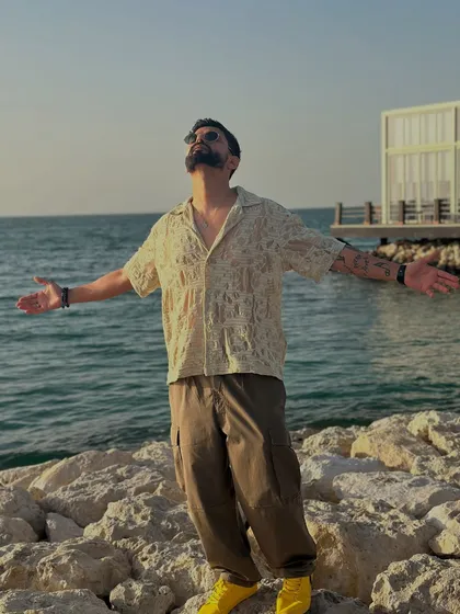 Arms wide open, embracing the beautiful sunset and the sea. A picture of pure bliss.