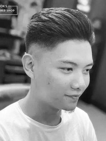 This black and white shot highlights the volume and texture of a modern pompadour, combined with a clean, faded side for a high-contrast, stylish look.