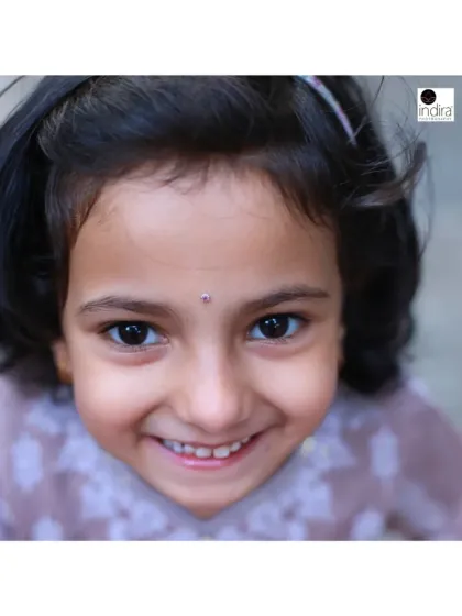 A sweet, close-up portrait of a young girl with a genuine, happy smile. By shooting from her eye level, I connect directly with her, making the portrait feel personal and engaging.