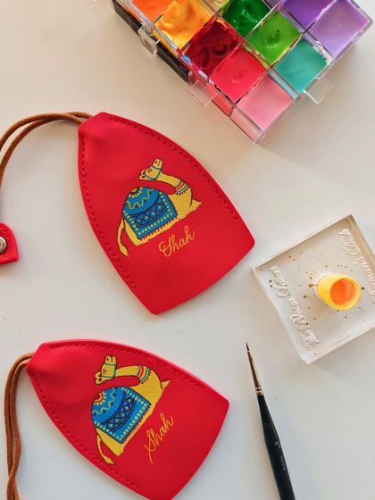 The tools of the trade. My paints, brush, and the finished hand-painted camel keychains, each one a small piece of art.