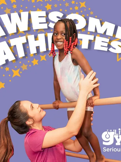 An instructor lifts a young girl onto the bar, a look of pride and trust on their faces. This is how I build 'Awesome Athletes', through encouragement and hands-on guidance.