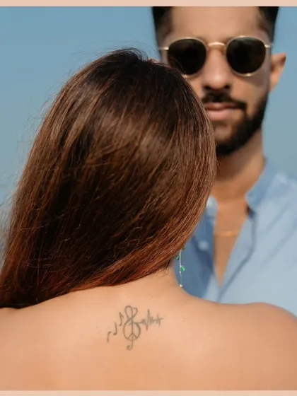 An artistic portrait focusing on a unique detail, like a tattoo, during a beach photoshoot. I always look for these personal elements to incorporate into your story.
