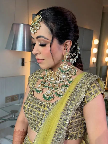 A side profile showing the beautiful, soft eye makeup and the intricate jewelry. The look is balanced and elegant.