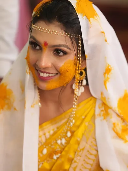 A happy, smiling close-up of the bride during her Haldi ceremony.