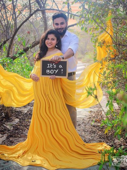A fun gender reveal moment during their outdoor maternity session. The couple's happy smiles and the "It's a boy!" sign make this a joyful memory to cherish.