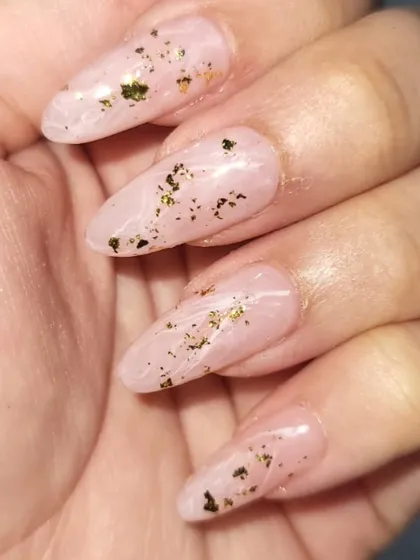 This design features a milky, marbled base with delicate gold foil flakes scattered throughout. The effect is subtle, elegant, and looks beautiful on these almond-shaped extensions.