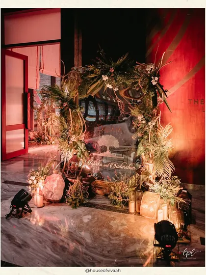 An entrance arch for the Sangeet, crafted from rustic branches, foliage, and soft candlelight, creating a natural and enchanting welcome for guests.