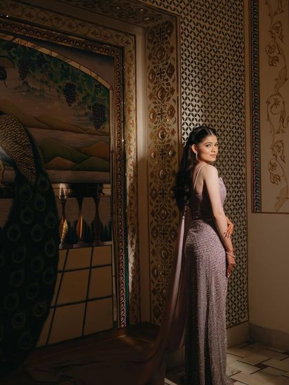 A stunning bridal portrait against an ornate wall, the bride's pose and expression exuding grace and confidence.