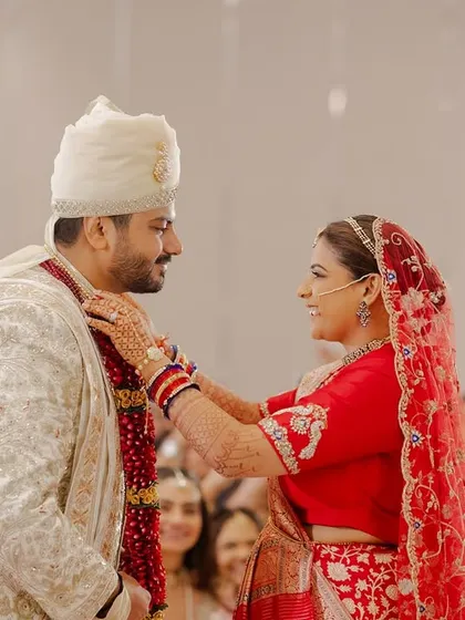 The bride places the garland on her groom, a playful and happy moment during the Varmala ceremony. We help orchestrate these traditions to be fun and engaging.