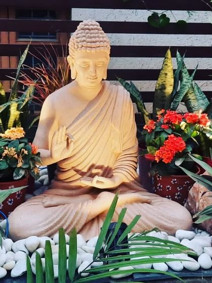 The same Buddha statue with lighting that accentuates its peaceful features, making it a stunning focal point at dusk.