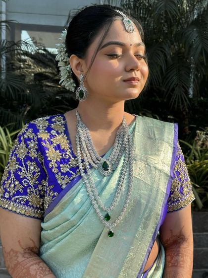 Glowing skin and a gajra never go wrong together. This bride's look features softly defined eyes, flushed cheeks, and a glossy nude lip to balance her bold blouse.