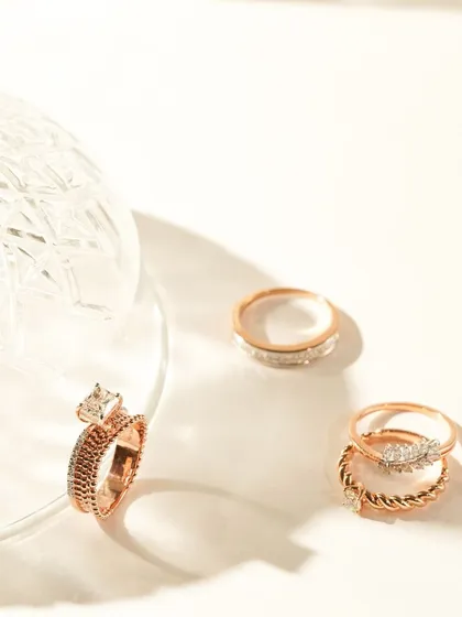 This image captures the beauty of rose gold rings in a minimalist setting. The play of light and shadow, along with the elegant glassware, gives the shot a sophisticated and artistic feel.
