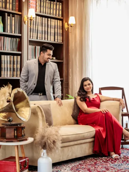 A candid moment in the library, where the groom looks lovingly at his bride. The vintage gramophone and bookshelves add a touch of old-world charm to this pre-wedding photo.