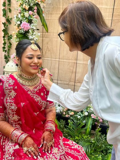 Another shot of the final touches. The bride's smile shows her comfort and trust in the process, which is essential for a calm and happy wedding day.