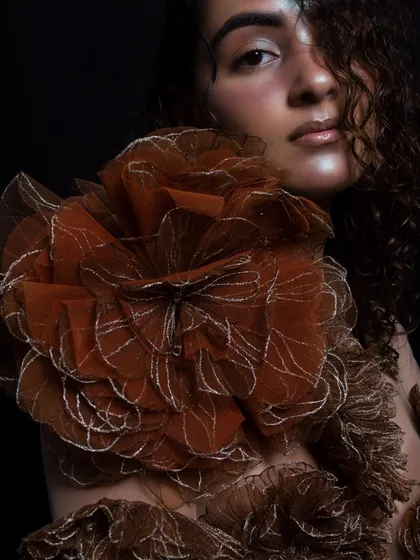 A close-up focusing on the texture of the garment and the glowing, dewy makeup. The highlight on the cheekbone and the wet-look hair create a cohesive, luminous effect.
