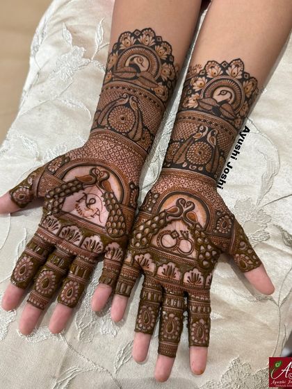 This engagement mehendi for Ankita is filled with graceful peacocks and includes the couple's initials 'A' and 'N' within a heart.