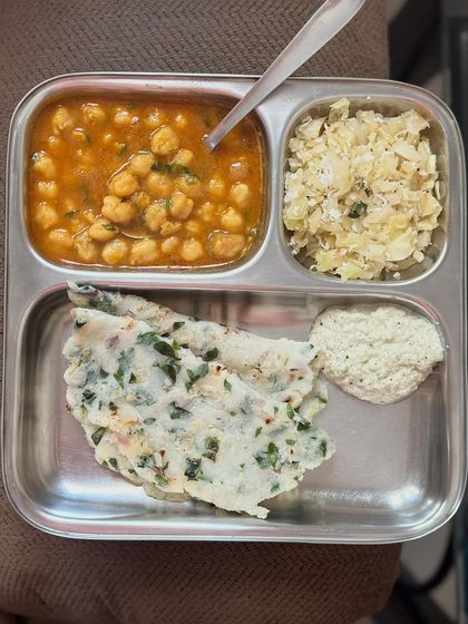 A traditional South Indian breakfast of akki roti (rice flour flatbread) with chana masala, cabbage palya, and coconut chutney.