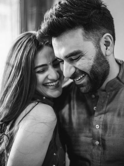 A black and white photo of a couple sharing a genuine, hearty laugh. We asked them to look at each other, and this magical, candid moment happened naturally.
