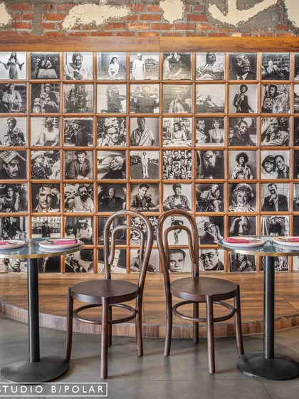 At Melthouse cafe, we created a nostalgic, lived-in atmosphere with a gallery wall of black-and-white portraits. This feature wall, paired with classic bentwood chairs, adds a layer of storytelling and old-world charm, making the space feel like a timeless European neighborhood pub.