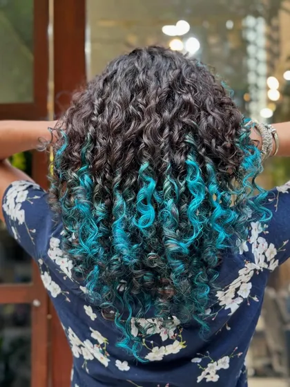 Who says you can't have fun with color? This vibrant turquoise dip-dye adds a playful pop of personality while keeping the roots natural and the curls healthy and defined.