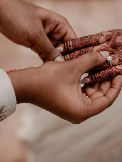 The symbol of a lifelong promise. We focus on the small but significant details, like the exchange of rings, capturing the intricate henna and the profound meaning of this moment.
