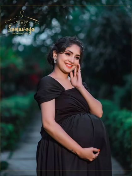 A classic black gown is always elegant. In this outdoor portrait, the mother-to-be's smile radiates pure joy.