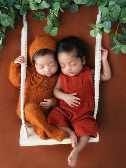 Two tiny humans, side by side on a miniature swing. This image is about remembering not just how little they were, but how close they always were to each other.