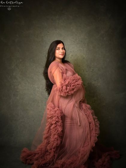 A classic three-quarter portrait that showcases the ruffled sleeves and soft fabric of this popular maternity gown.