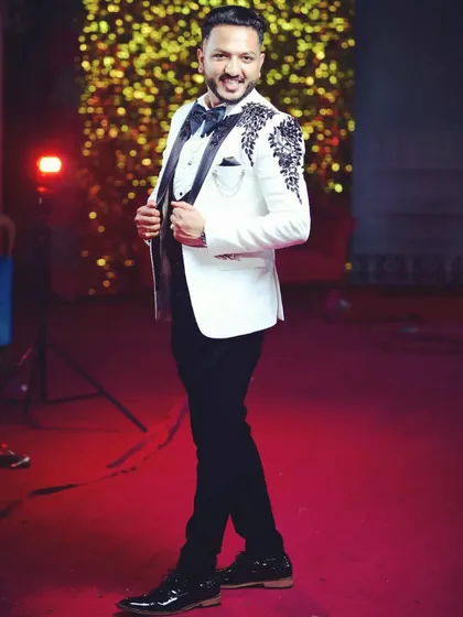 Look sharp and confident at your reception or cocktail event. This client is wearing a custom-tailored white tuxedo jacket with a modern three-piece construction, detailed with unique black embroidery on the lapels and shoulders.