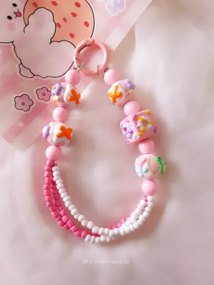 A detailed shot of the pink and white candy-themed beaded charm, perfect for adding a sweet touch to your phone or bag.