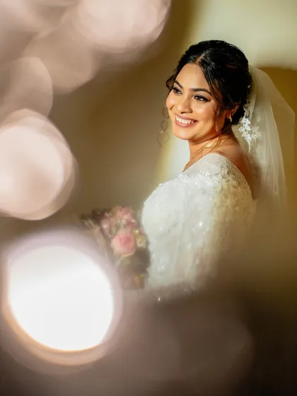 A beautifully lit portrait of the bride, her smile radiant and her makeup flawless.