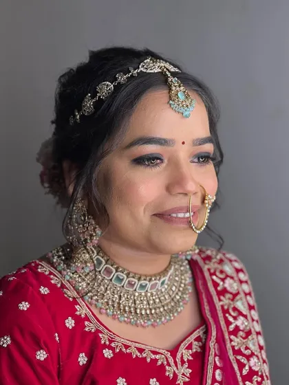 A final portrait of this stunning bride. The makeup is soft, radiant, and perfectly suited for her traditional red wedding attire.