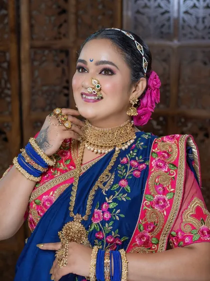 A vibrant and traditional look, featuring a blue and pink embroidered saree, perfect for festive occasions.