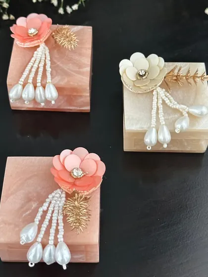 These resin boxes, decorated with delicate floral and pearl tassels, are a modern and elegant option for a coin box or a small jewelry gift. The soft pastel colors are perfect for a daytime event.