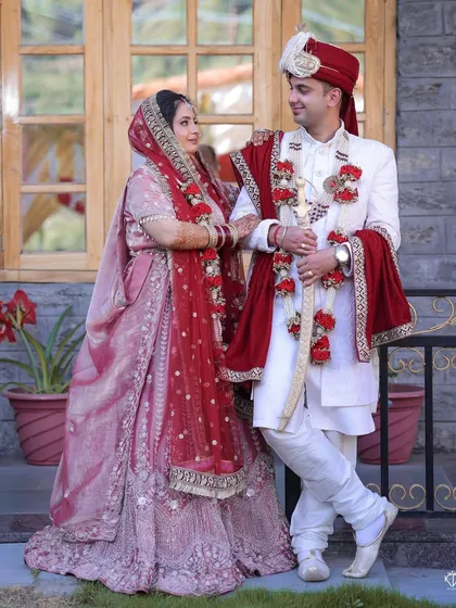 A classic portrait of the bride and groom in their wedding attire, showcasing a beautiful Himachali wedding.