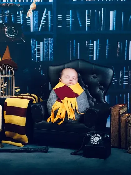 A wider shot of the newborn Harry Potter theme, showcasing the detailed props like the owl, vintage phone, and caged birds.