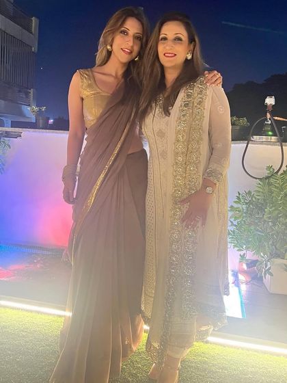 Posing with my sister. We're both in sarees, showing our different personal styles.